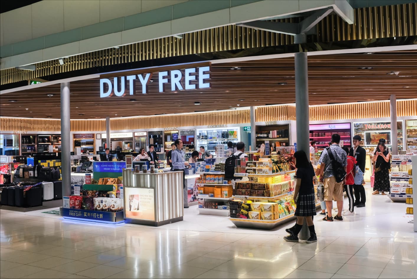 Passengers walking past a duty-free store airside